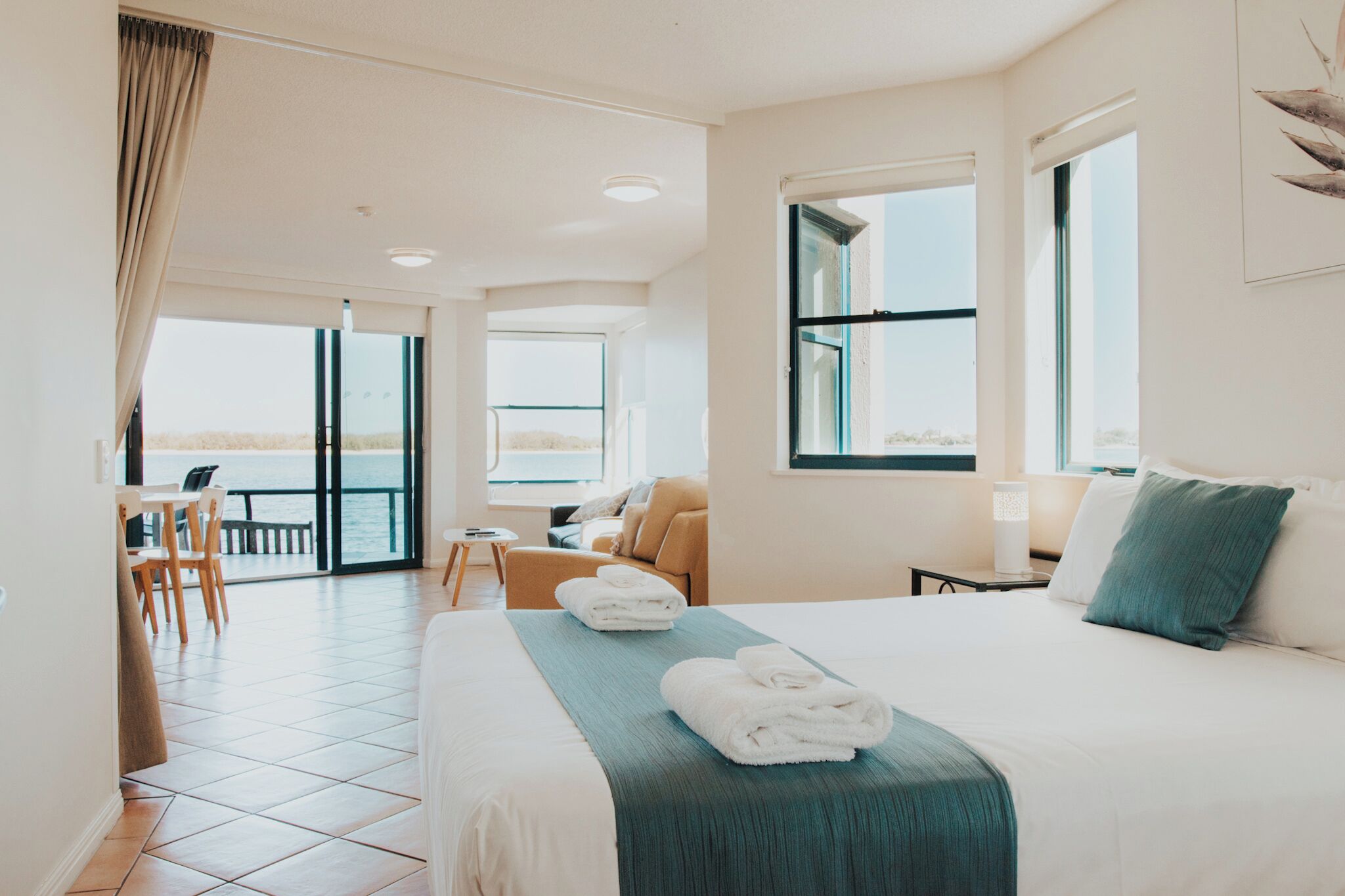 Habitación de hotel con una cama, un escritorio, una silla y vistas al mar.