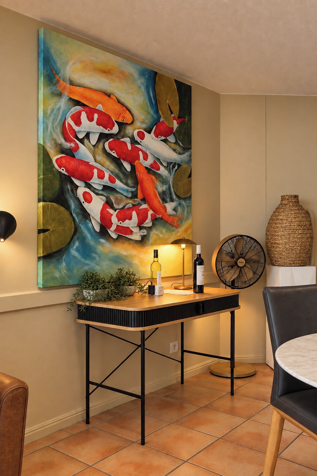 Un coin repas comprenant une table, des chaises, un ventilateur, un vase et un tableau représentant des carpes koï, accroché au mur.