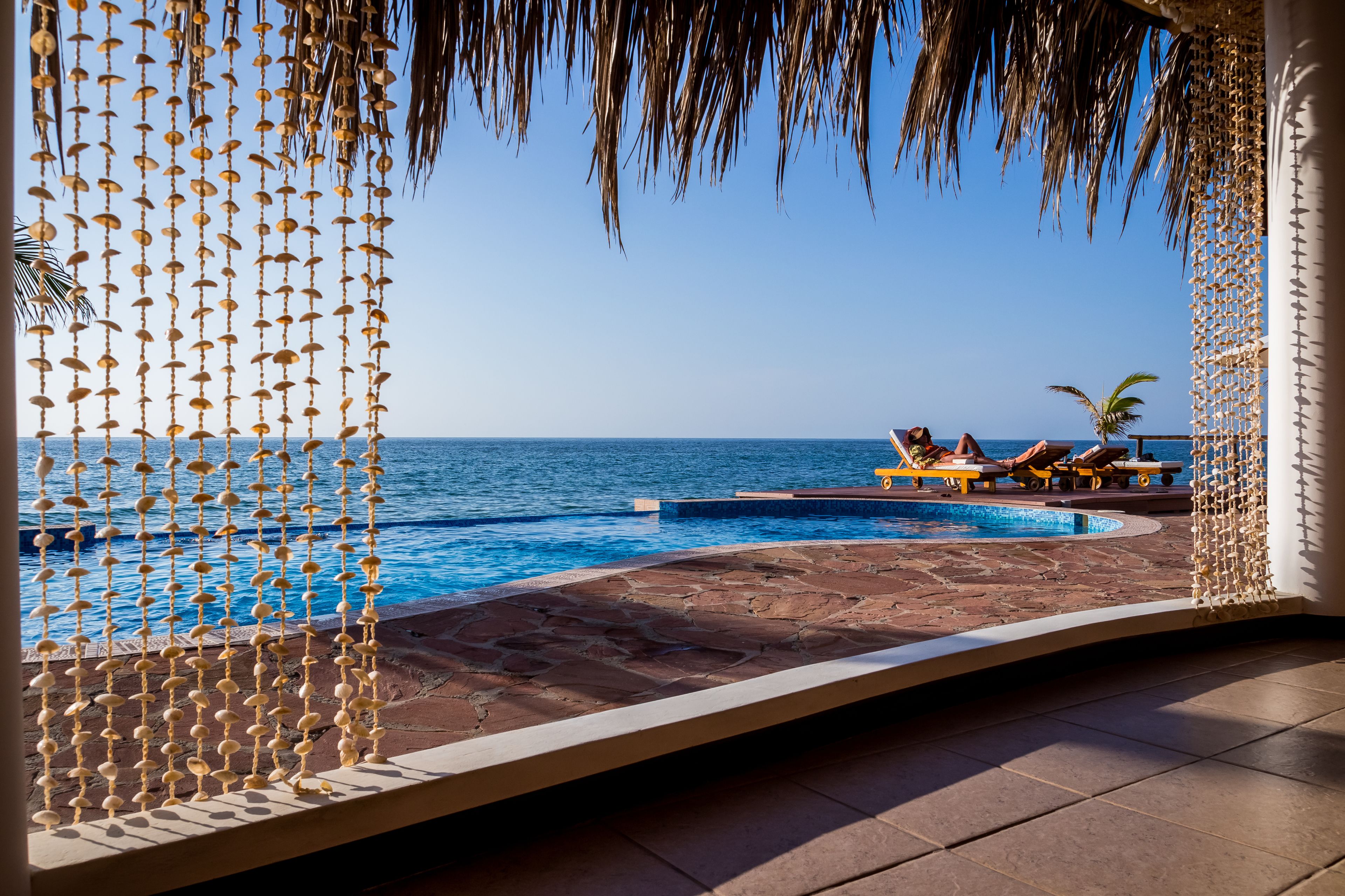 Een buitenzwembad, parasols bij het zwembad en ligstoelen