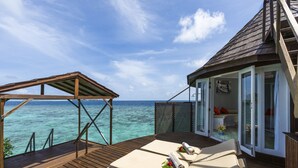 A wooden deck with two lounge chairs and a covered area overlooking the ocean. - Nika Island Resort & Spa (Kudafolhudhoo)