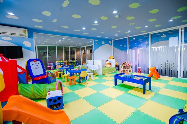 A children's play area with colorful mats, play tables, and toys.