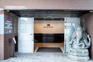The entrance to a hotel with a sign reading 'ROYAL HOTEL' and a statue of an elephant. - Royal Hotel (Yomitan)