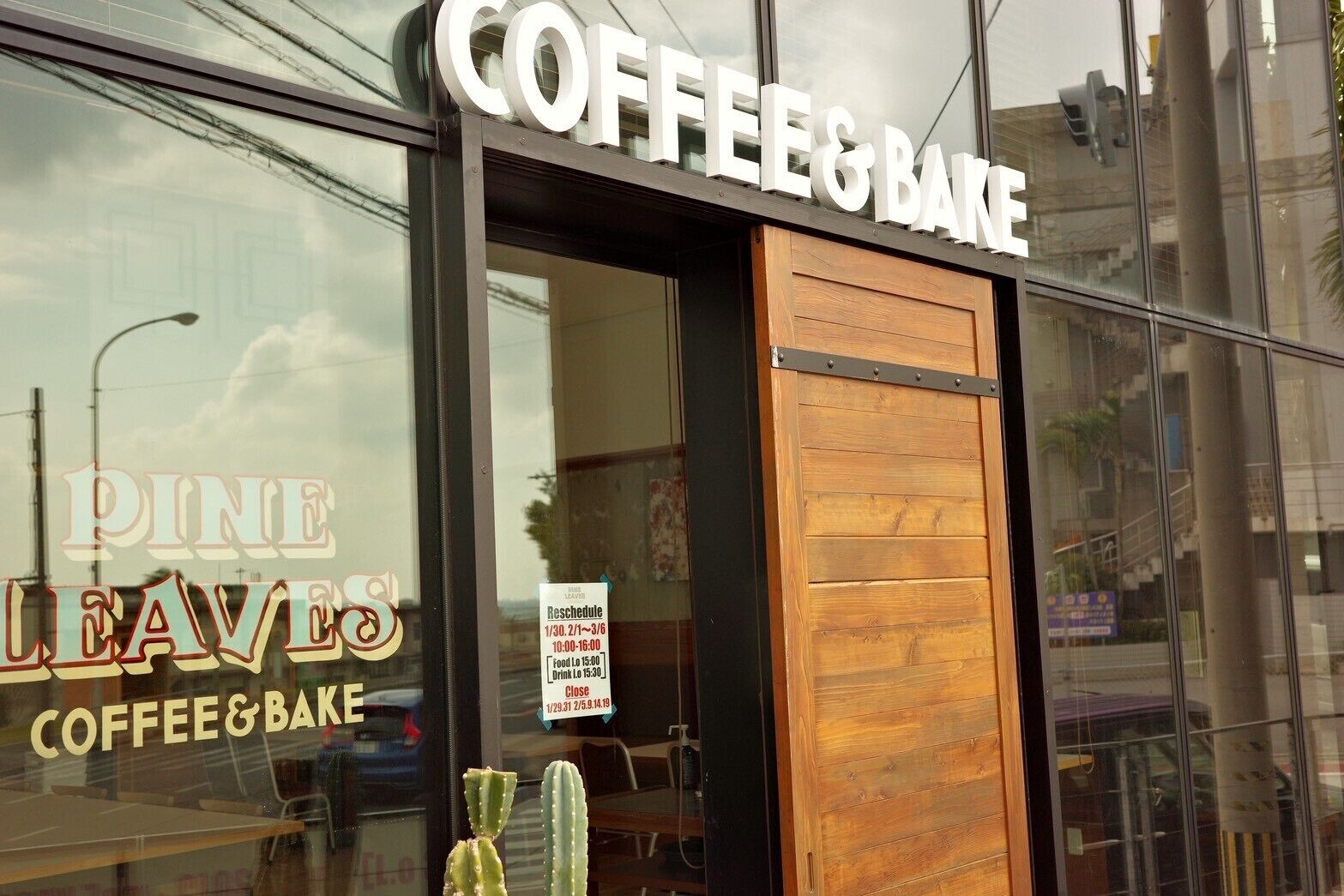Una fachada con un letrero que dice 'Coffee & Bake' y una vitrina con un cactus.