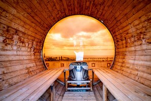A sauna with wooden benches and a large window. - Royal Hotel (Yomitan)