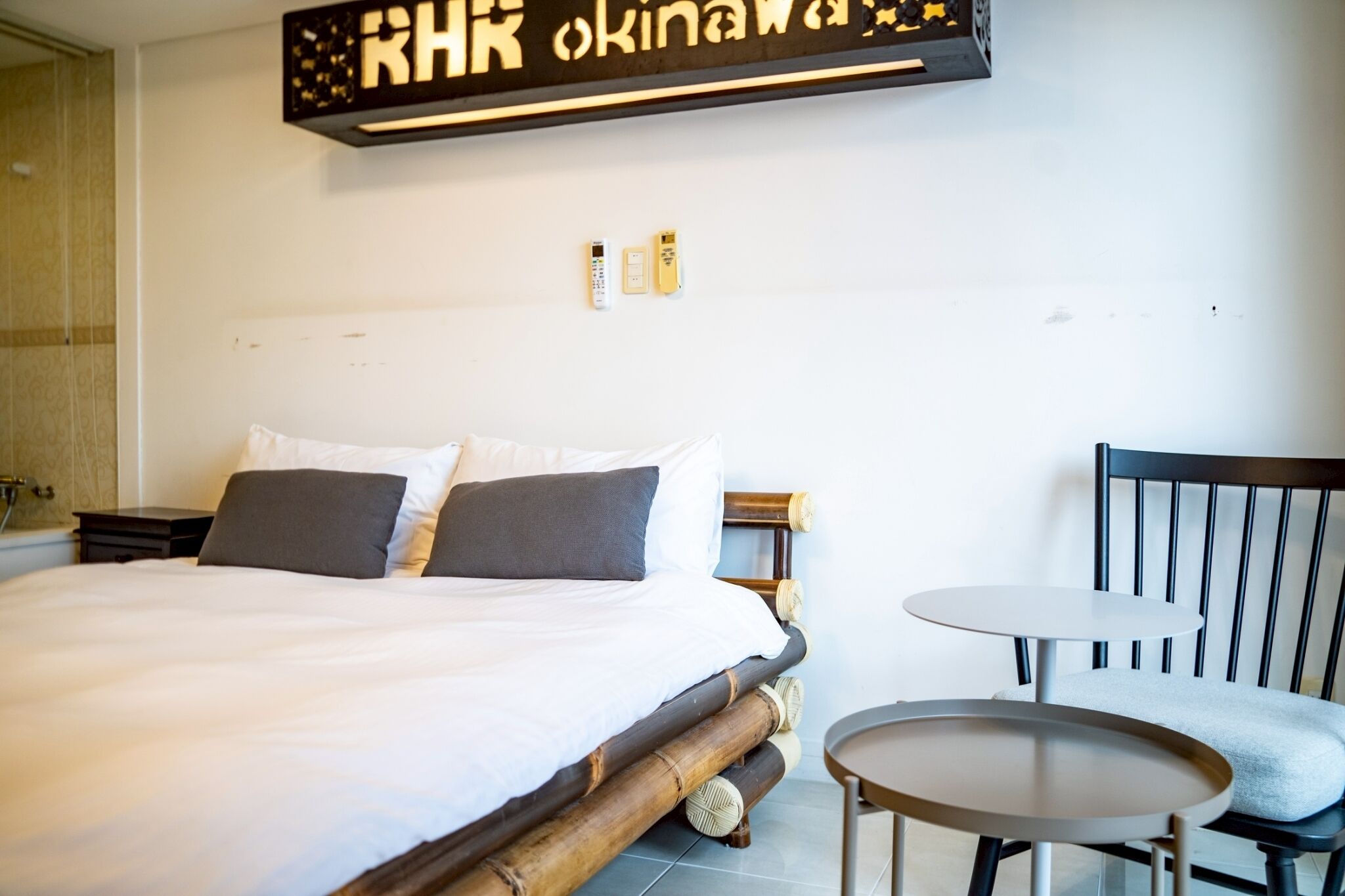 Una habitación de hotel con una cama grande, dos mesitas de noche, una pequeña mesa redonda y una silla.