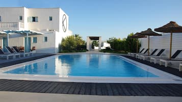 Una piscina al aire libre de temporada, sombrillas