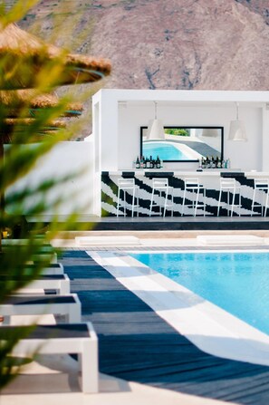Una piscina al aire libre de temporada, sombrillas, tumbonas