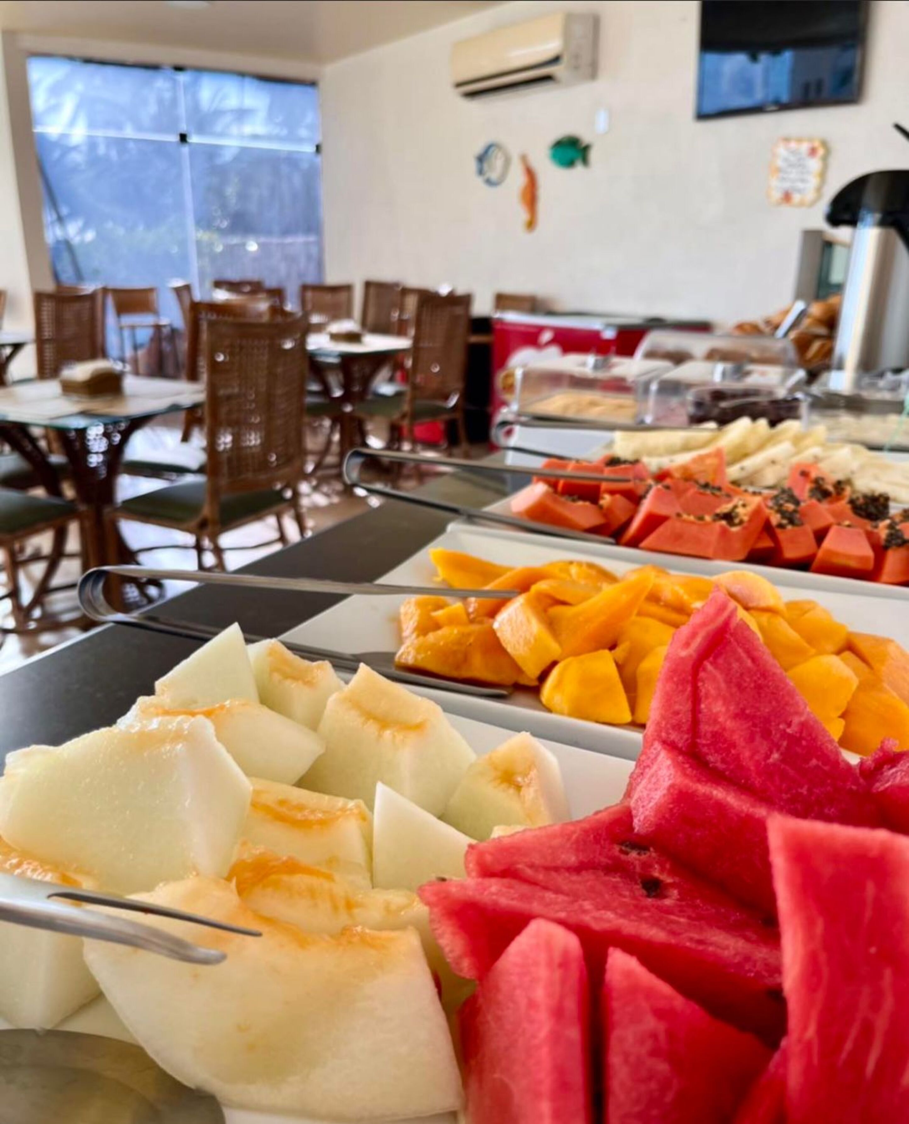 Ein Buffet mit verschiedenen Früchten und ein Essbereich mit Tischen und Stühlen.