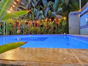 Una piscina al aire libre, sillones reclinables de piscina