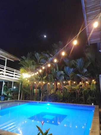 Una piscina al aire libre, sillones reclinables de piscina