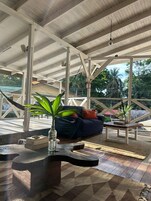 Un salón al aire libre con una hamaca, un sofá y una mesa de centro.