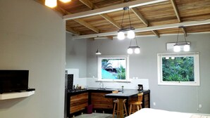 Una cocina moderna con armarios de madera, encimera negra y ventana con vistas a la vegetación.