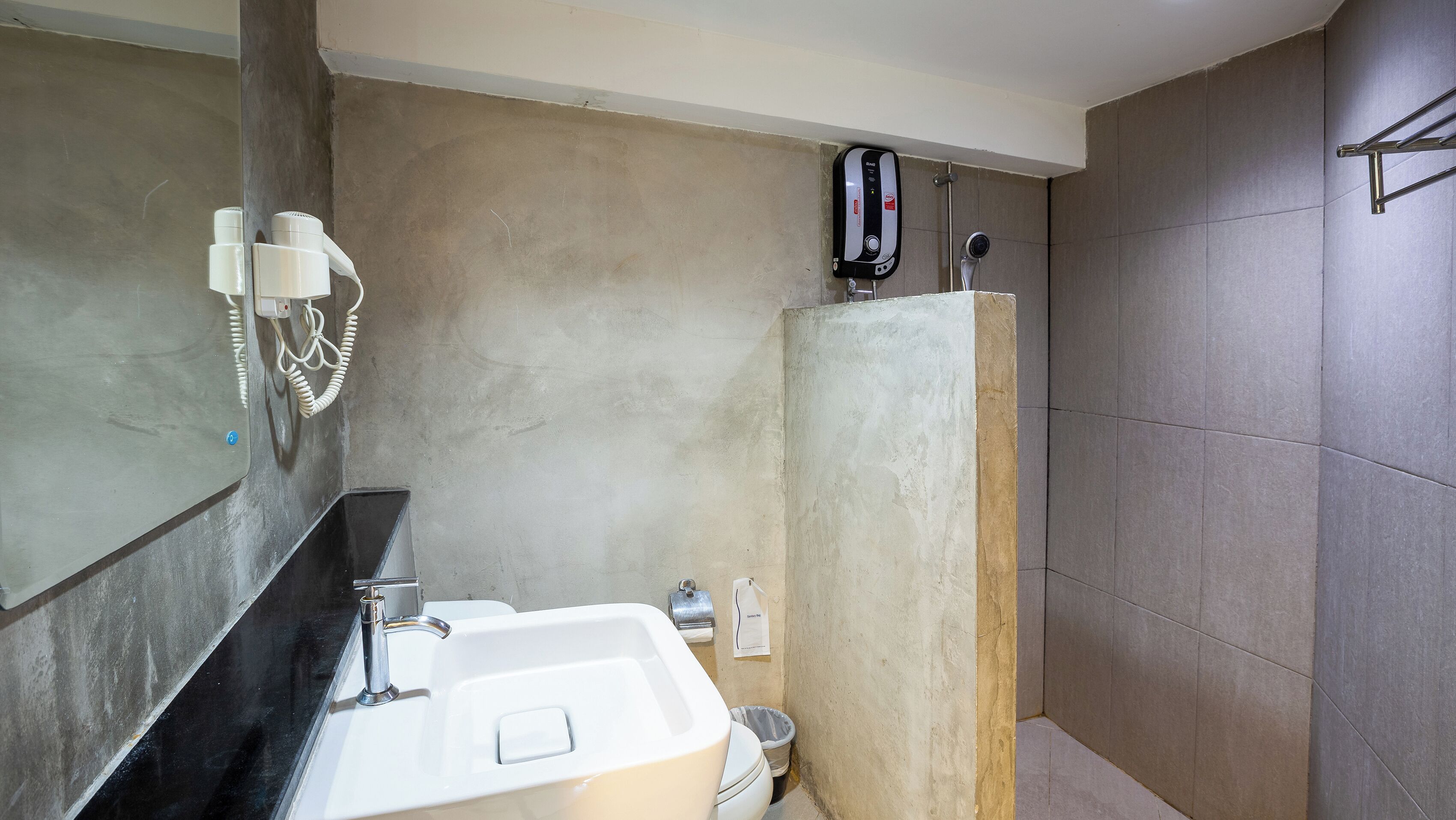 A bathroom with a sink, mirror, and a shower area.