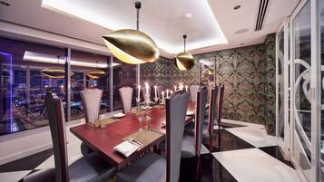Un comedor moderno con una mesa grande, sillas elegantes e iluminación colgante.
