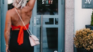 L’entrée d’un hôtel, avec une porte en verre, une enseigne indiquant « STORY BY HYATT » et un pot de fleurs placé à droite.