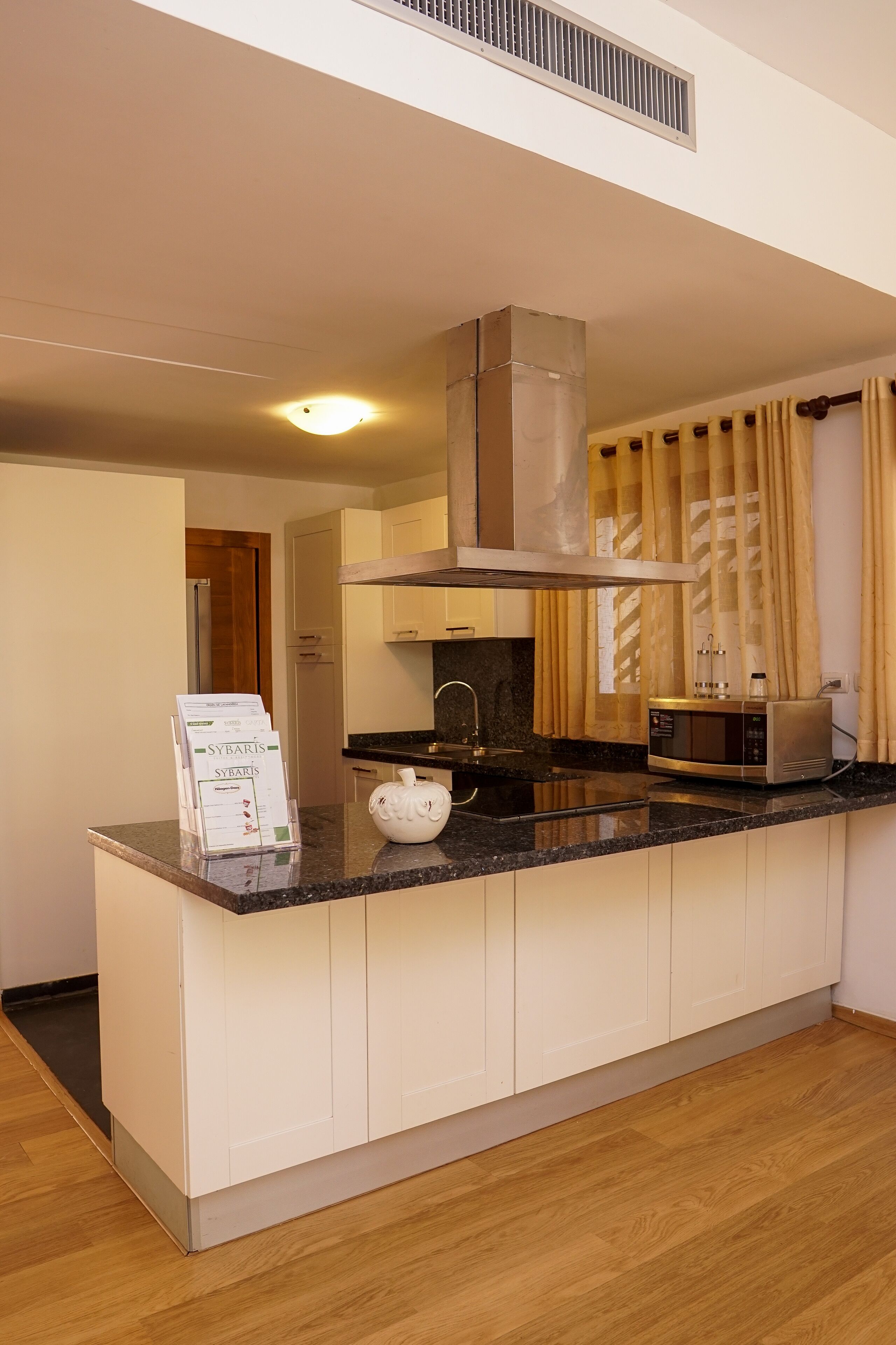 A modern kitchen with a built-in island, a microwave, and a kettle.
