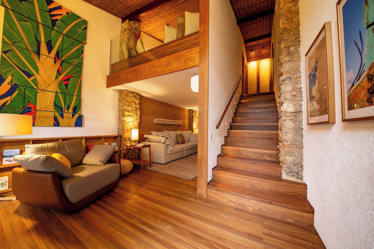 A spacious living area with a wooden floor, a sofa, a coffee table, and a large abstract painting on the wall.