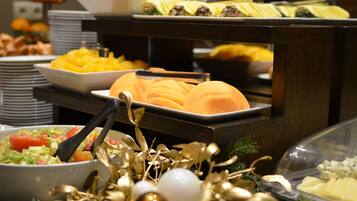 A buffet with various food items including fruits, vegetables, and salads.