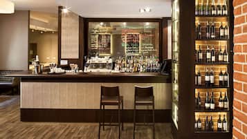 Una zona de bar con mostrador de madera, dos taburetes, una vitrina para vinos y un panel con la carta.
