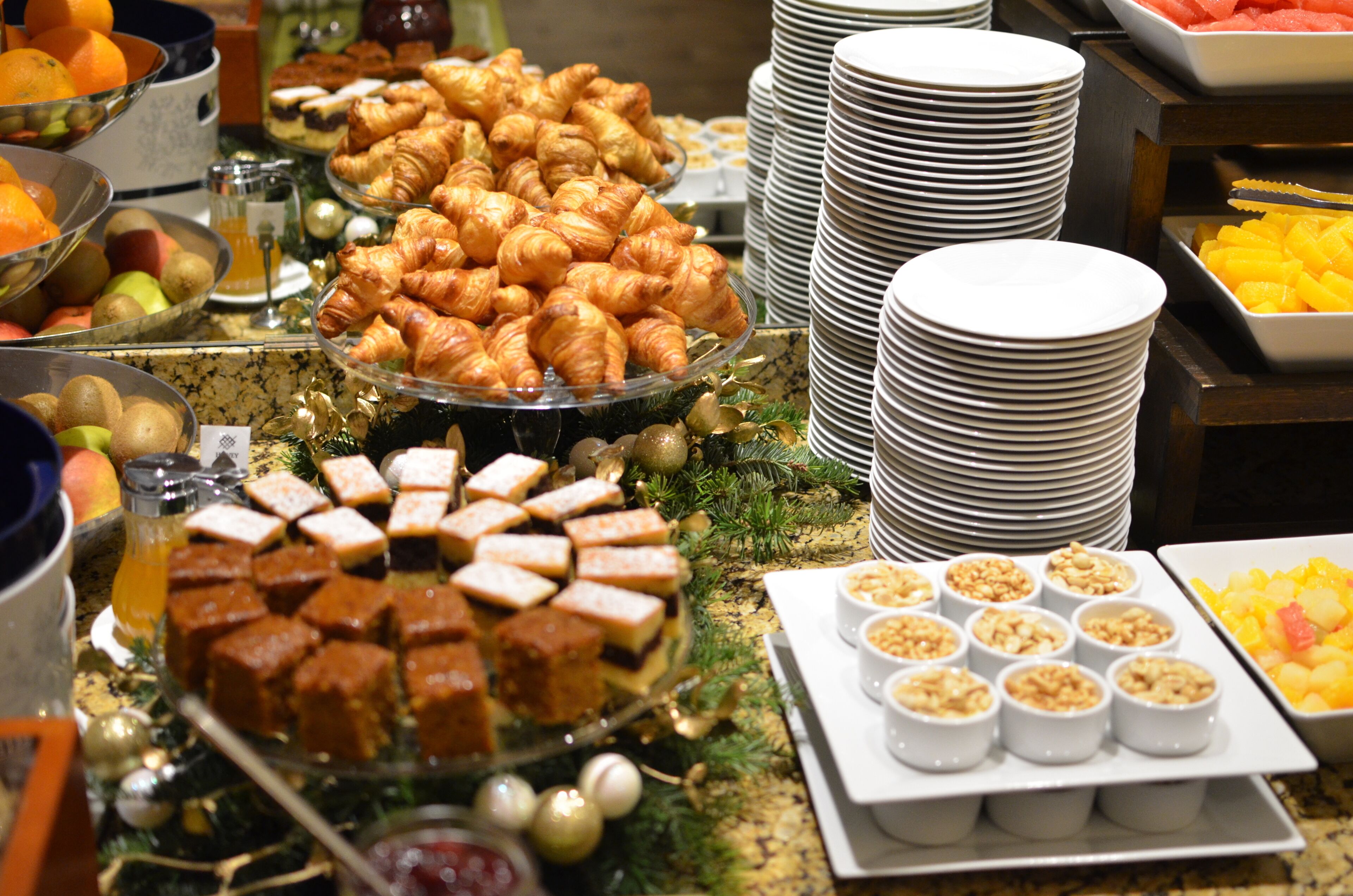 A buffet with various food items including pastries, fruits, and desserts.