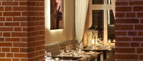 A restaurant with brick walls, wooden flooring, and a cozy ambiance with candlelight.