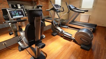 A gym with exercise equipment including a stationary bike, elliptical, and treadmill.