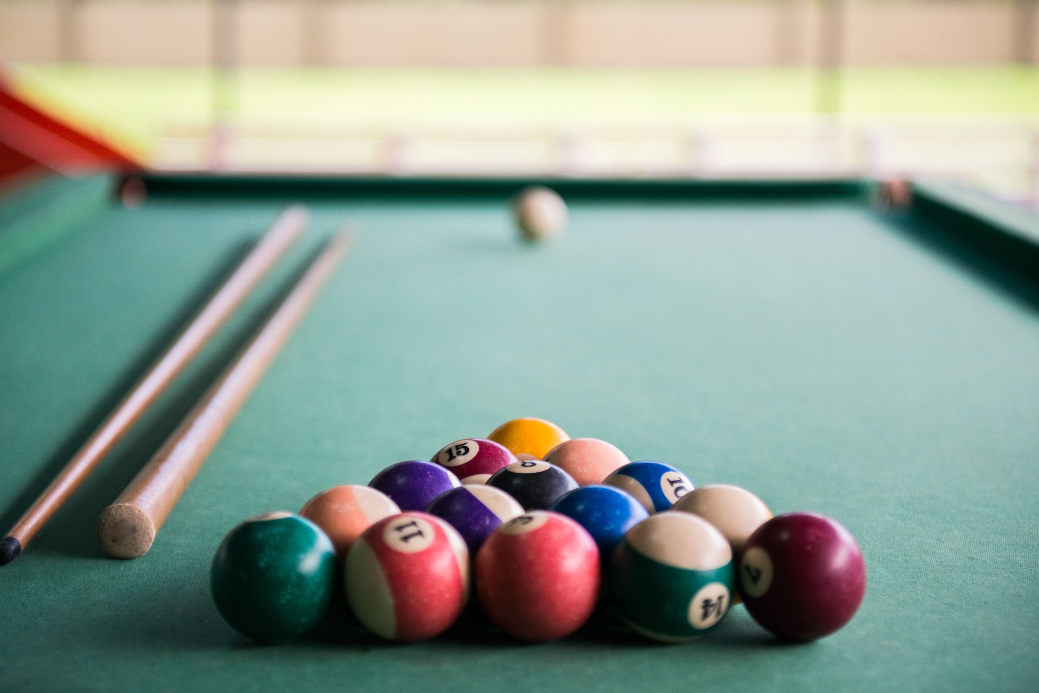 Une table de billard avec des billes et des queues de billard.