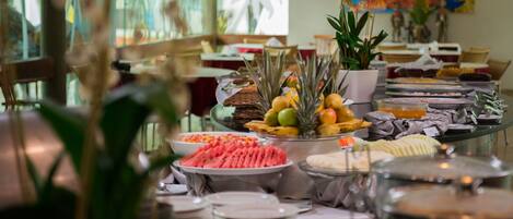 Un buffet con diversi cibi e un arredamento tropicale.
