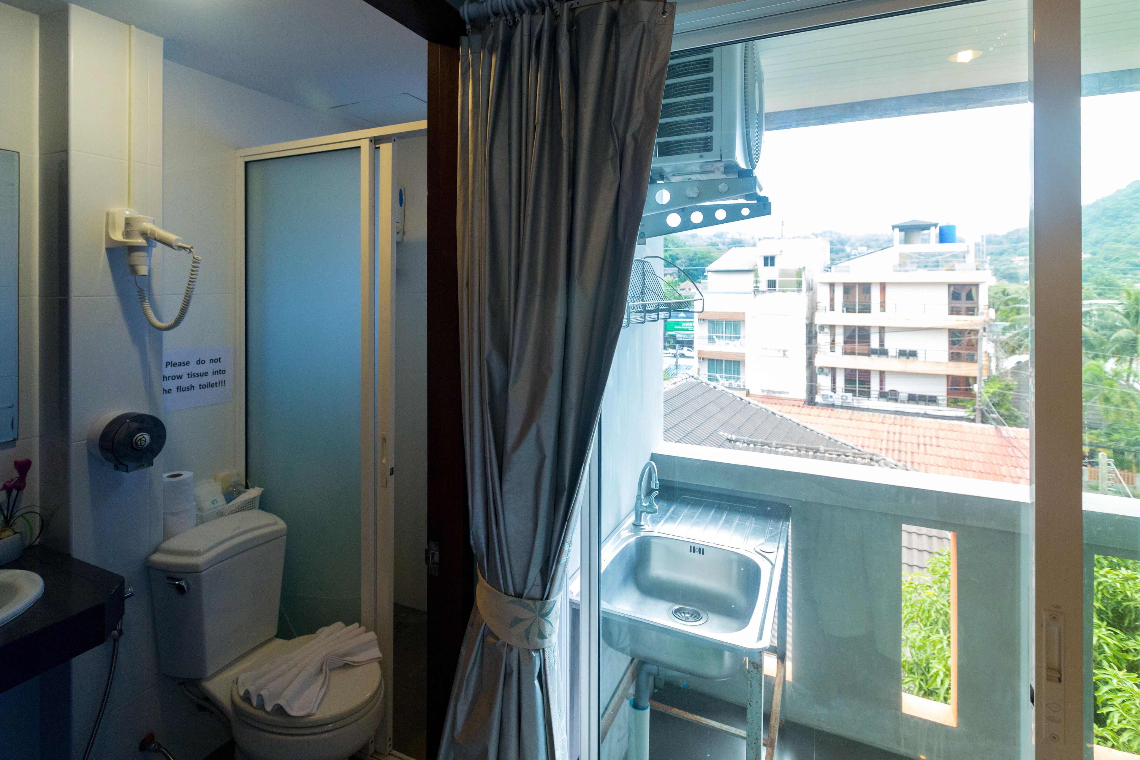 A bathroom with a toilet, sink, and shower.