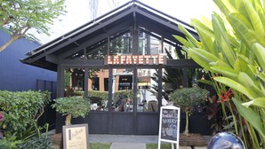 Ein Café namens 'Lafayette' mit Schild, das Frühstück, Bäckerei und Kaffee anbietet.
