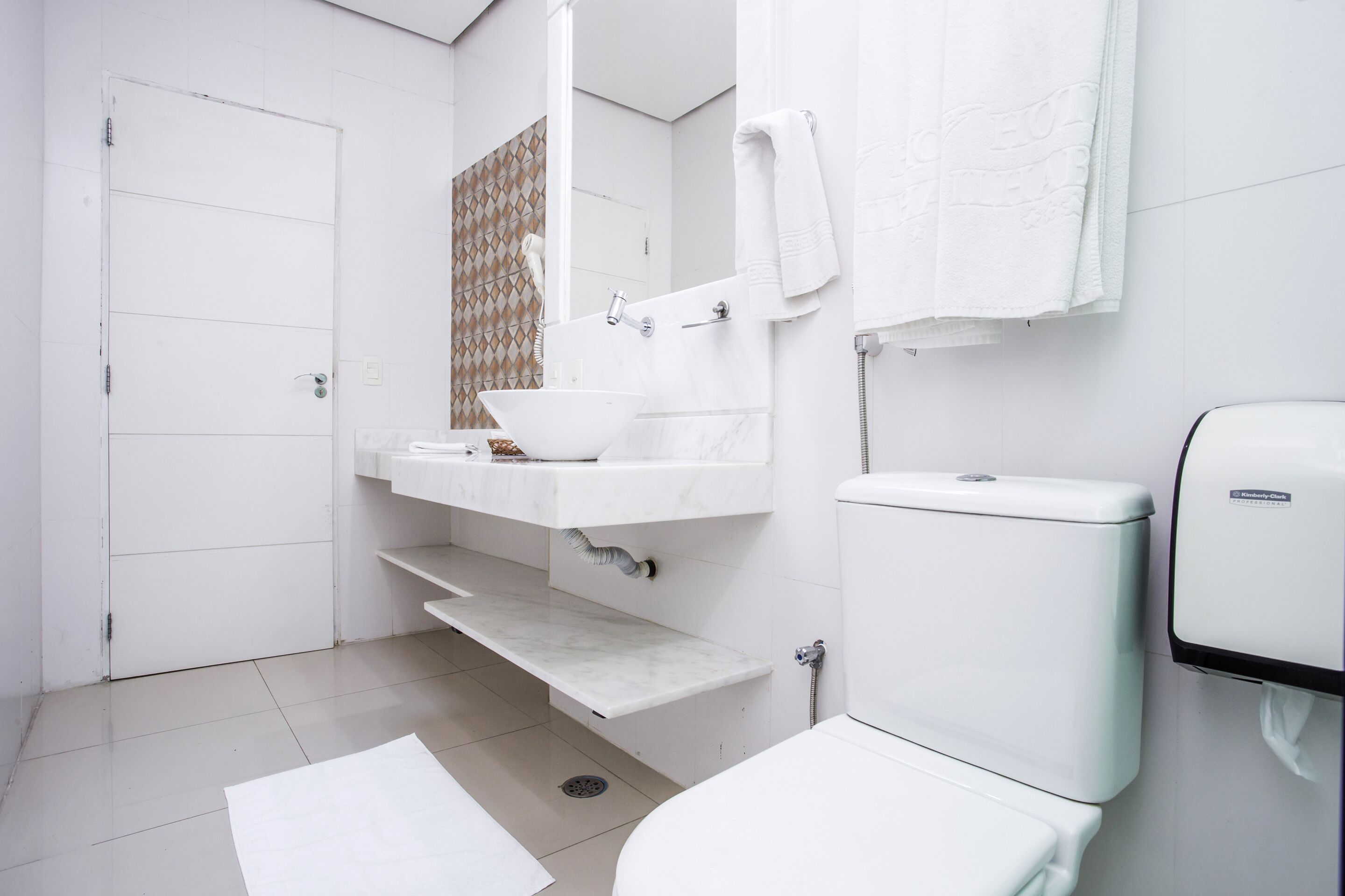 A bathroom with a toilet, sink, and shower.