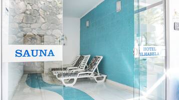 Relax in the sauna area with a glass door leading to the outdoors and comfortable lounge chairs.