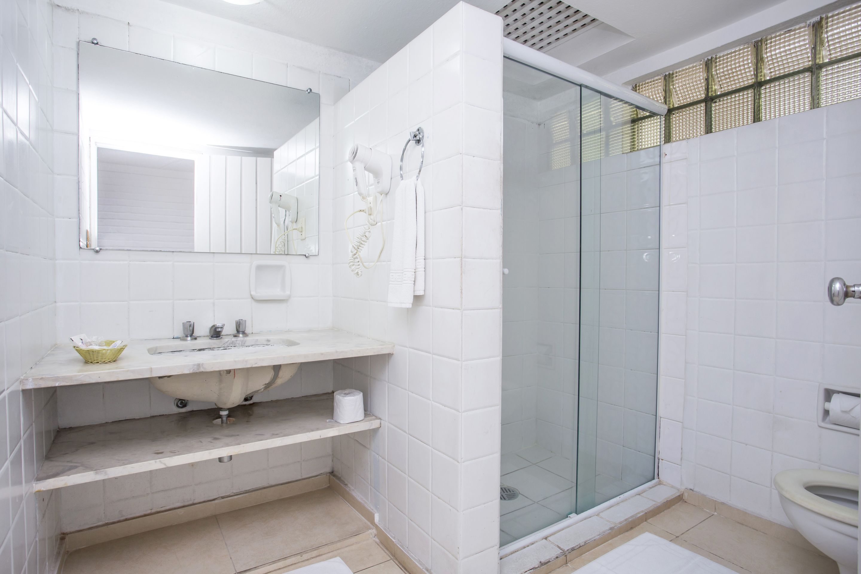 A modern bathroom with a glass shower enclosure, a sink with a vanity, and a toilet.