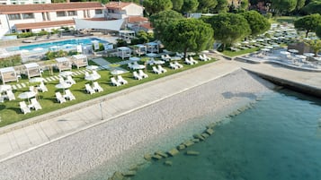 Una spiaggia nelle vicinanze, sabbia scura, lettini da mare, ombrelloni