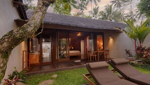 A bungalow with a private bathroom, a dining area, and a lounge with sun loungers. - Ubud Padi Villas (Ubud)
