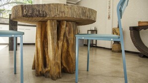 Una mesa redonda de madera con acabado natural, rodeada de sillas azules.