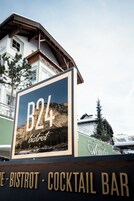 Señal de B24 Bistro & Cocktail Bar, con vista a la montaña.