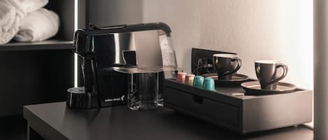 Eine moderne Küche mit Kaffeemaschine, einem Glas und einer Serviertablett mit Tassen und Gewürzen.