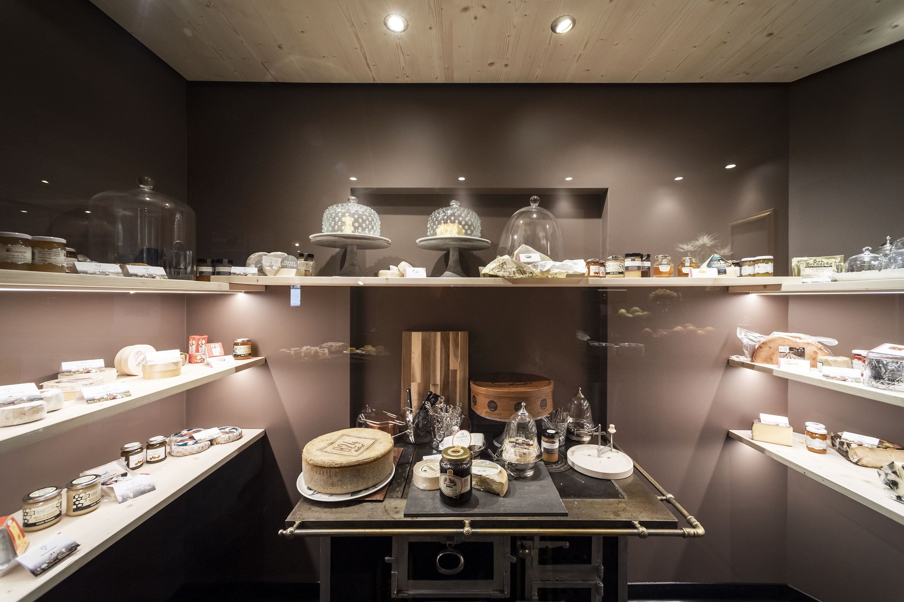 A well-organized display of various food items and kitchenware on shelves and tables, with a focus on dairy products and jars.