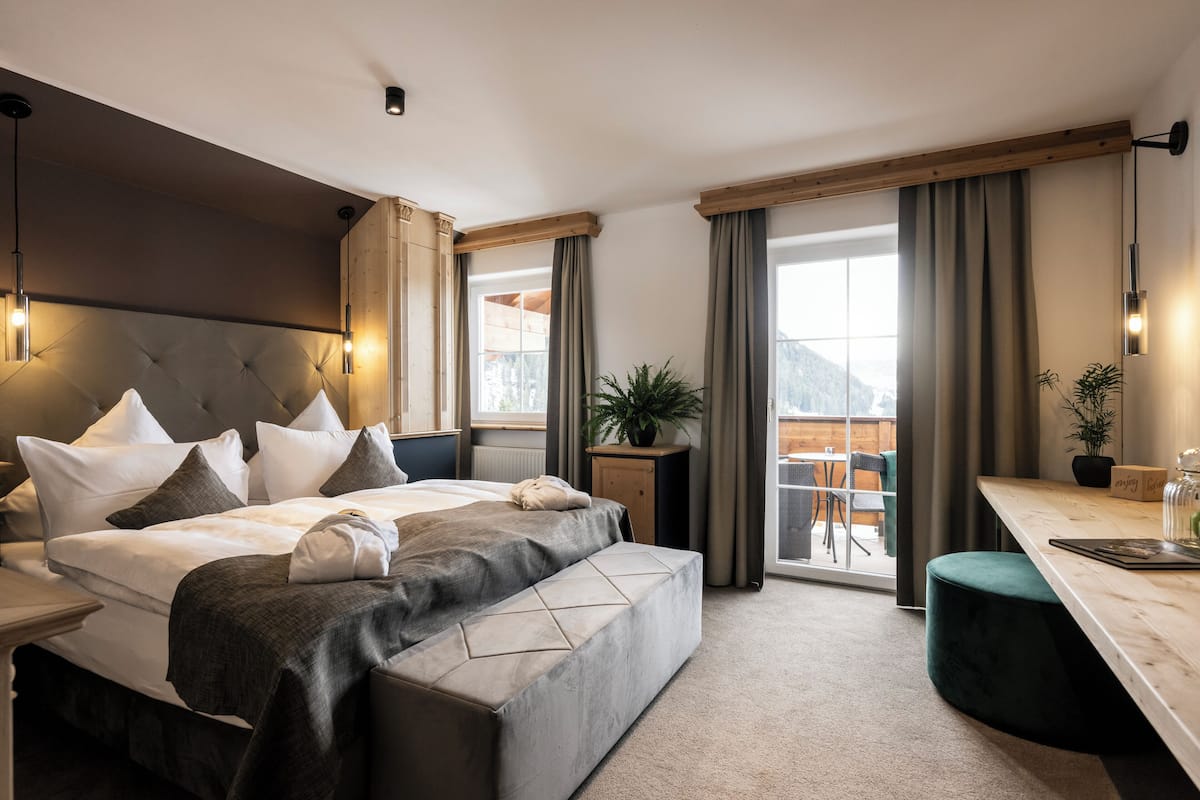 Un dormitorio moderno con una cama grande, un escritorio y vistas al exterior.