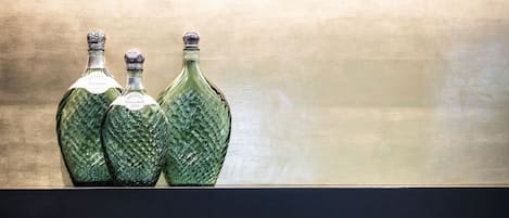 Three green glass bottles on a shelf against a dark background.