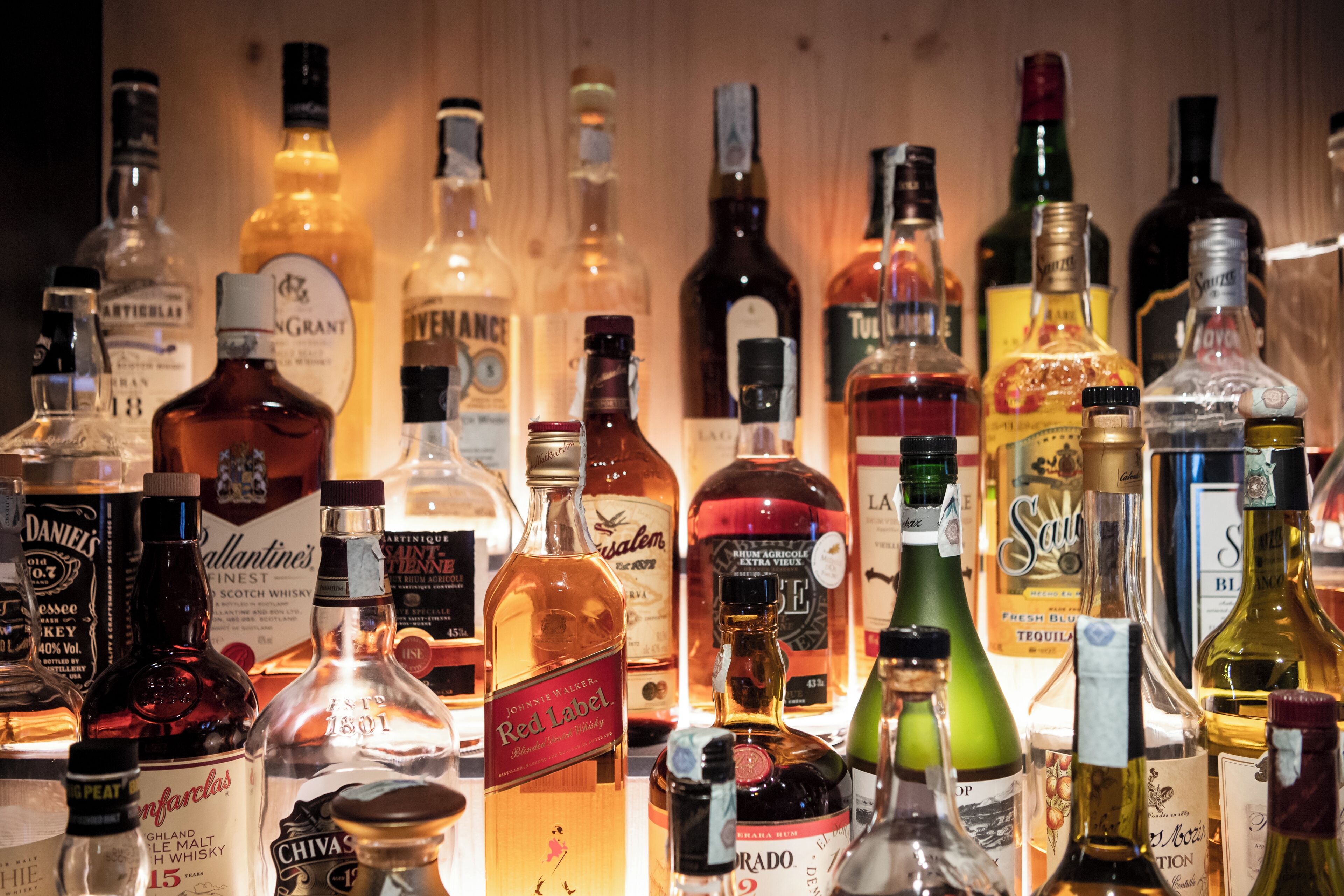 A variety of liquor bottles displayed on a shelf.