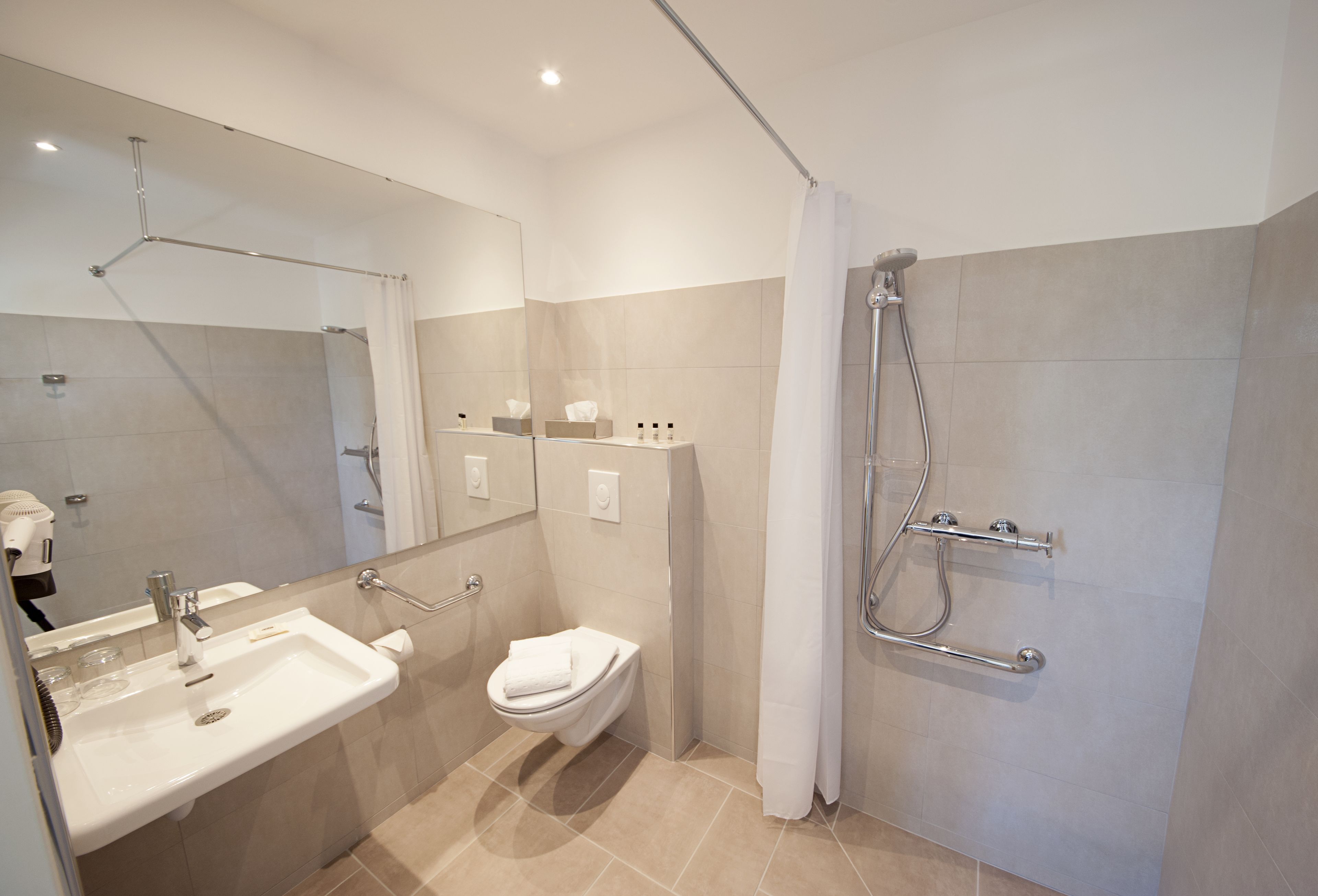 Une salle de bain moderne avec un lavabo, des toilettes et une douche.