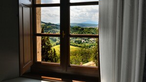 A window with a view of a green landscape and hills. - Il Tosco (Montepulciano)