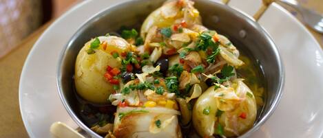 Un plato de mariscos con papas y hierbas.