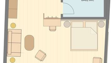 Distribución de una habitación con una cama, dos sillones, una mesita y un sofá. Hay un baño indicado con BAD/WC.