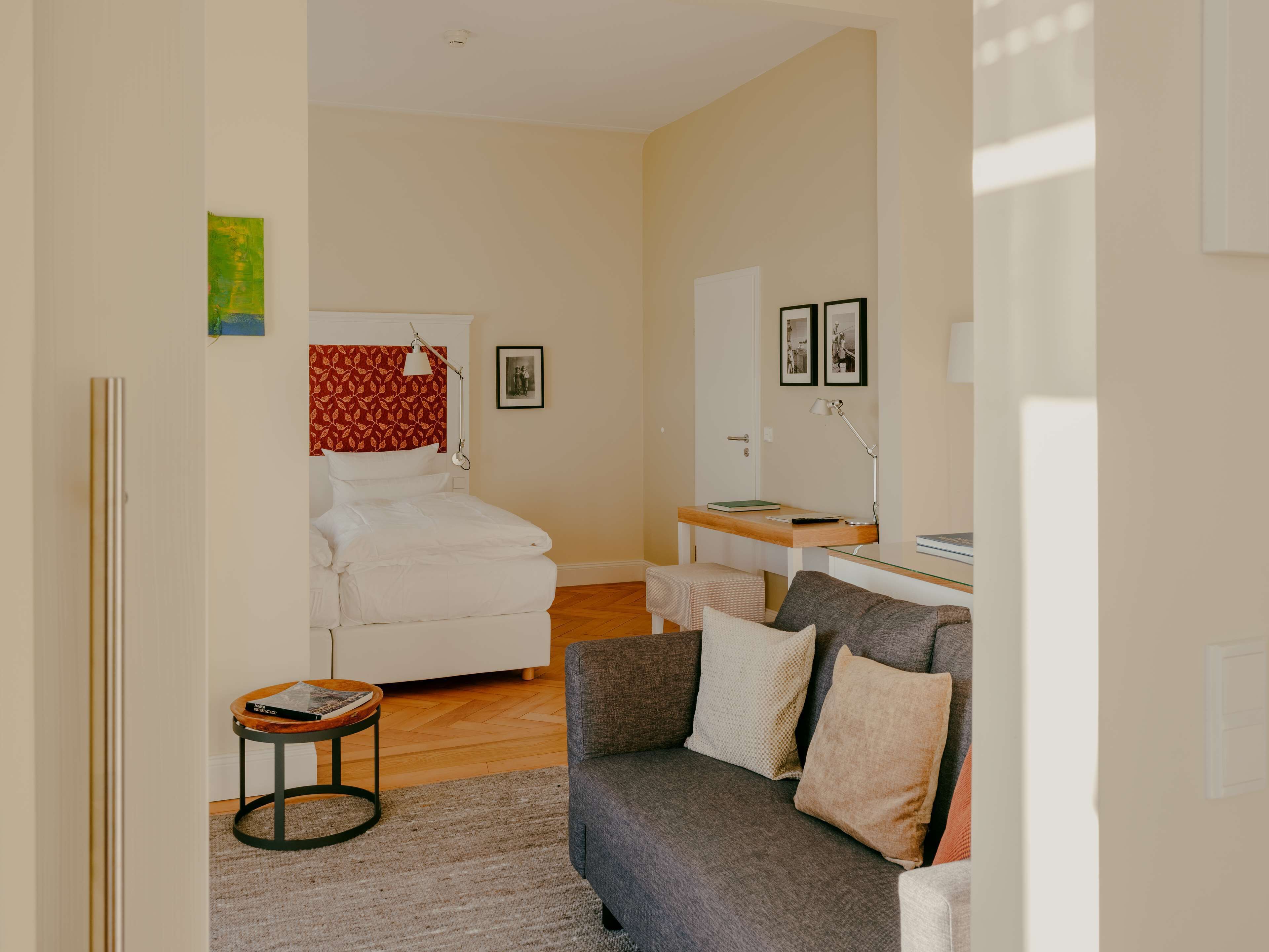 A bedroom with a bed, bedside table, and a desk with a chair.