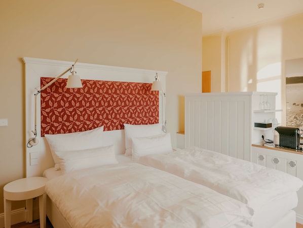 A bedroom with a bed, bedside tables, and a wardrobe. - Bad Hotel Überlingen (Ueberlingen)