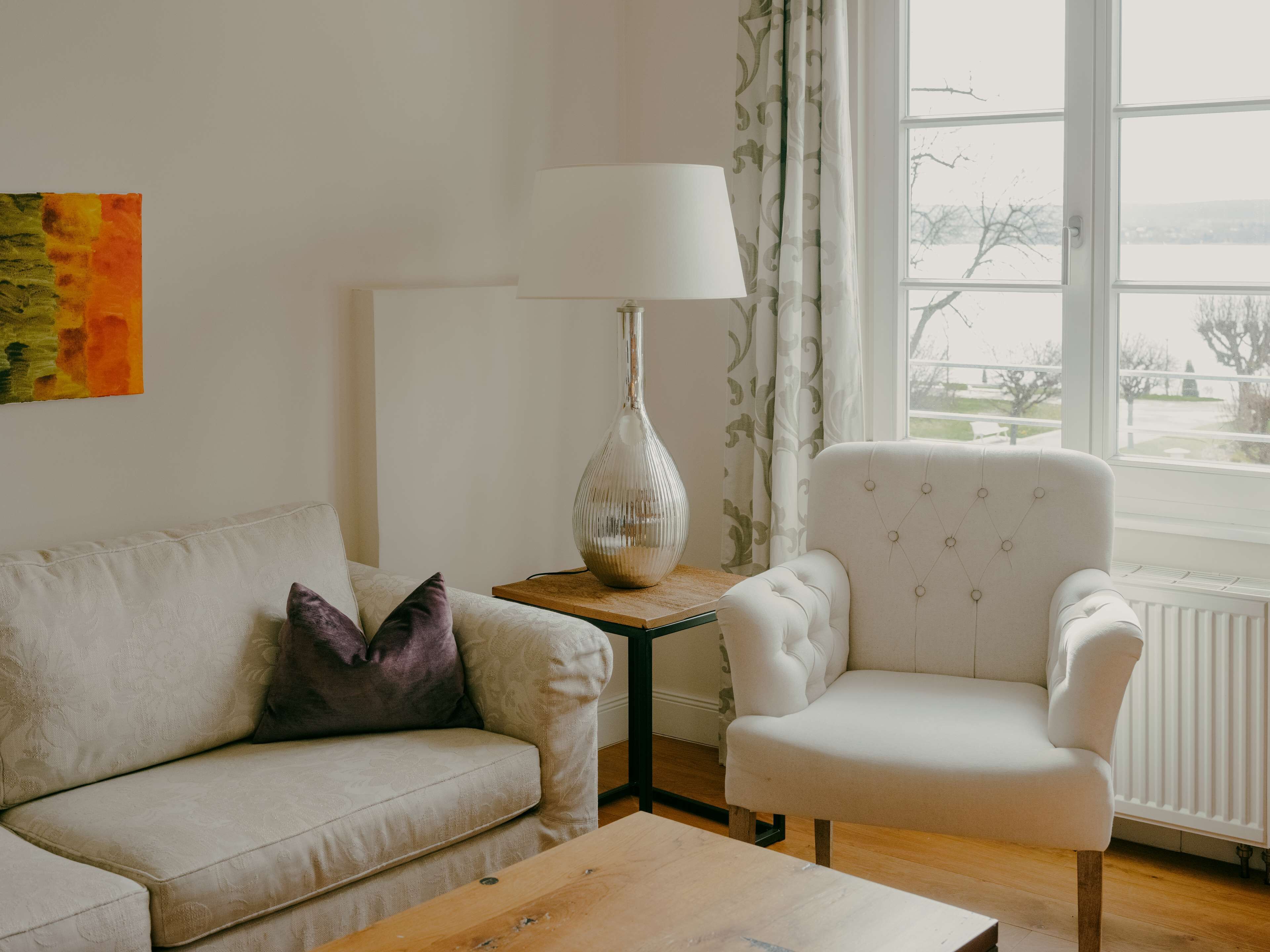 Ein Wohnzimmer mit einer Couch, einem Sessel und einem Tisch.