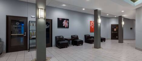 A hotel lobby with seating areas, a reception desk, and a CoolCryo machine.
